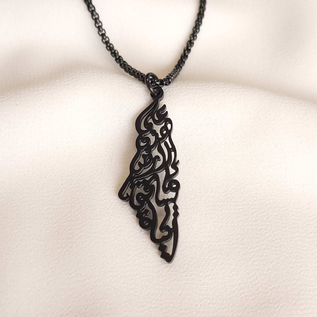 Black Palestine Calligraphy Necklace with an openwork map-shaped pendant and matching black chain.