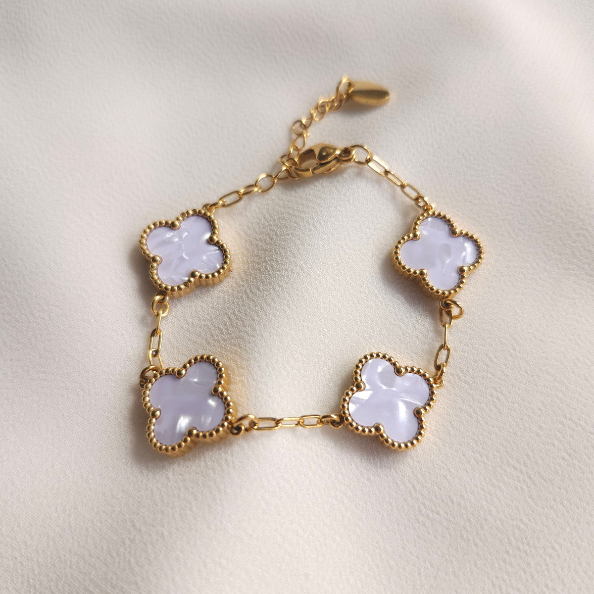 Children’s gold-tone bracelet with four pearly white clovers and beaded borders.
