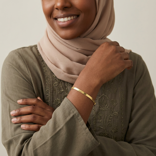 Classic Herringbone Bracelet worn on a wrist, showing the slim gold-tone chain lying flat against the skin.