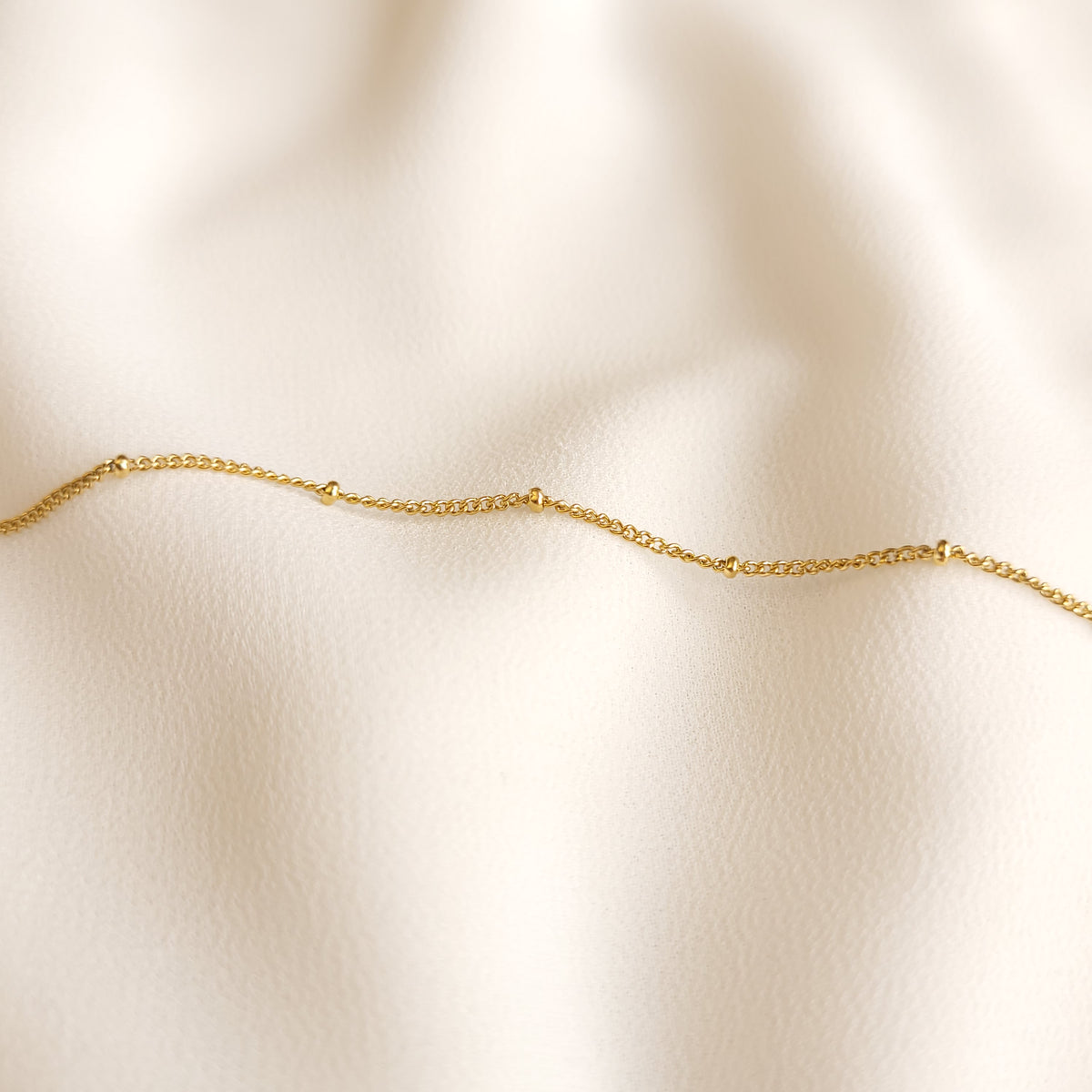 Detail of the Satellite Beaded Bracelet showing its fine gold-tone chain and evenly spaced beads.
