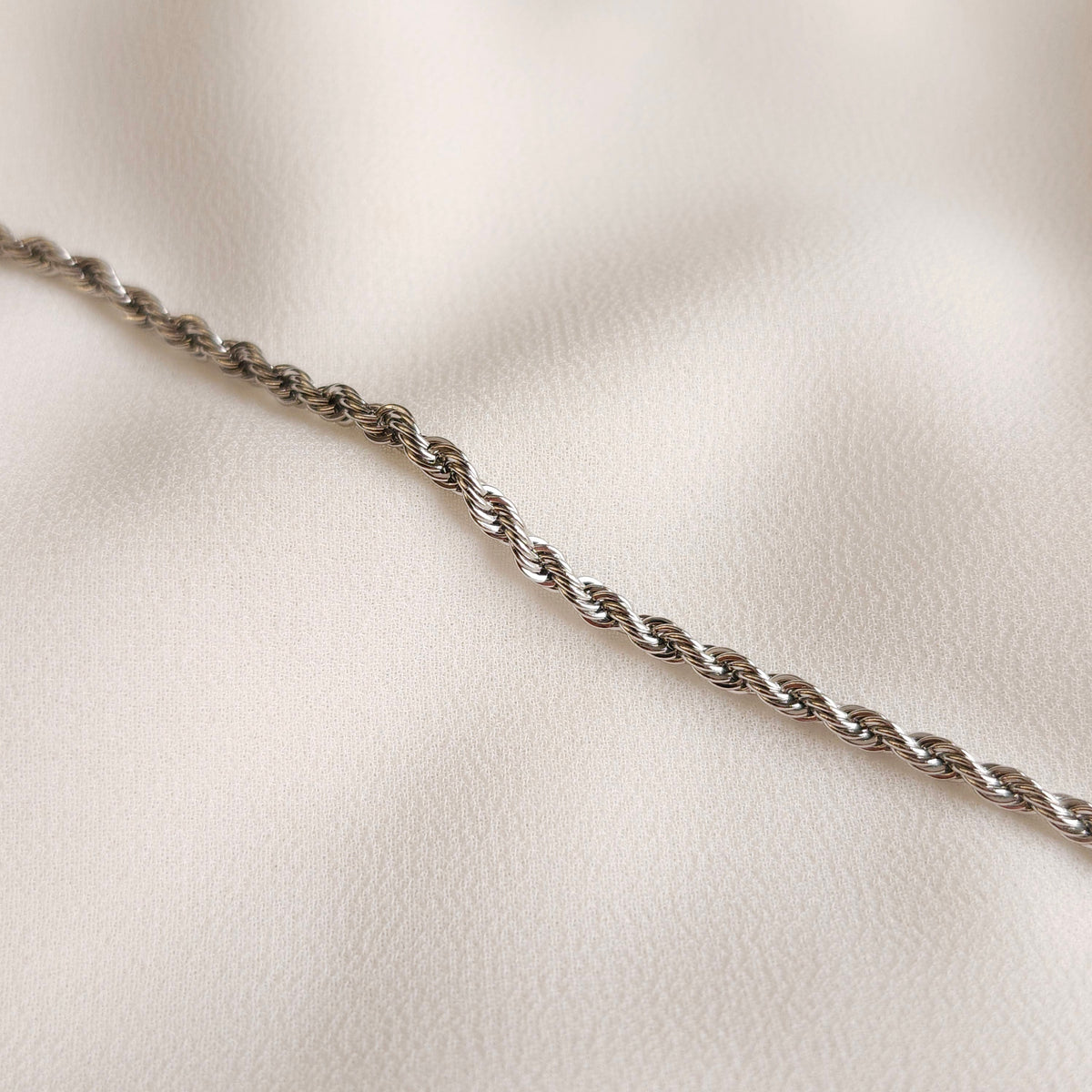 Essential Rope Necklace in silver tone, showing its slim intertwined links and polished finish.