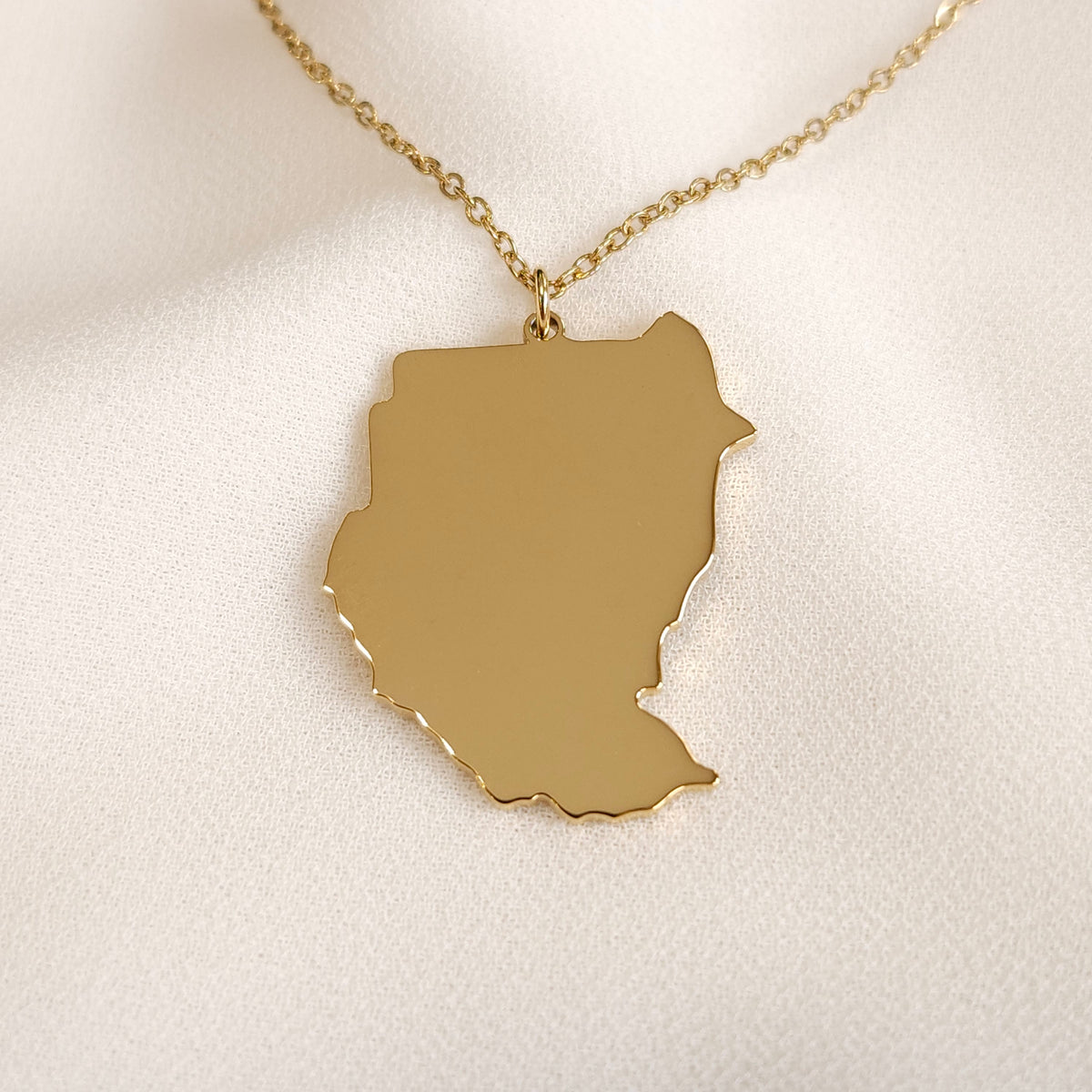 Front view of the gold-tone pre-split Sudan map pendant necklace.