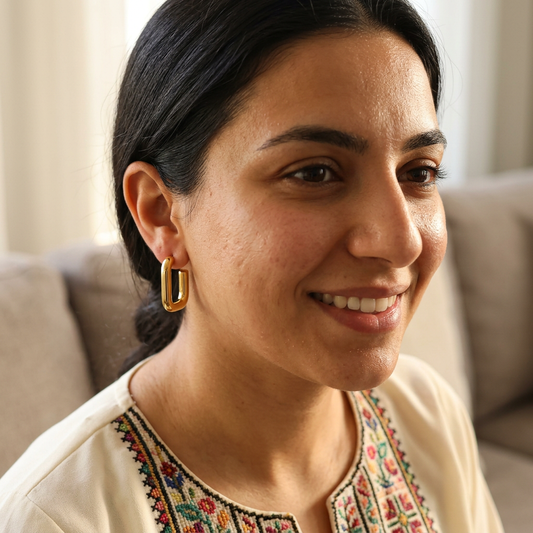 Geometric Square Earrings worn on an earlobe, showing the polished gold-tone shape with hair pulled back.