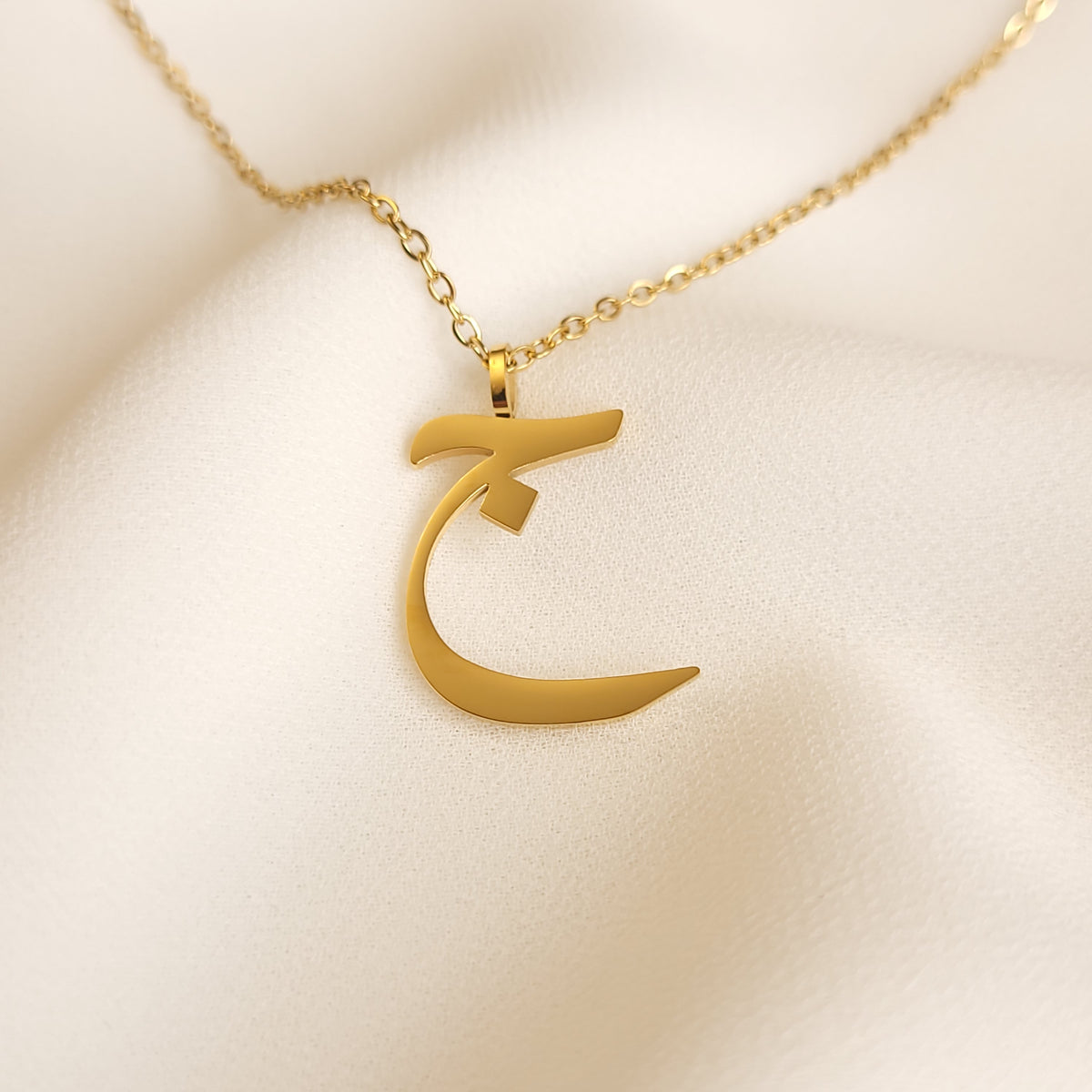 Gold-tone Arabic Initial Necklace with the letter Jeem (ج) on a fine link chain.