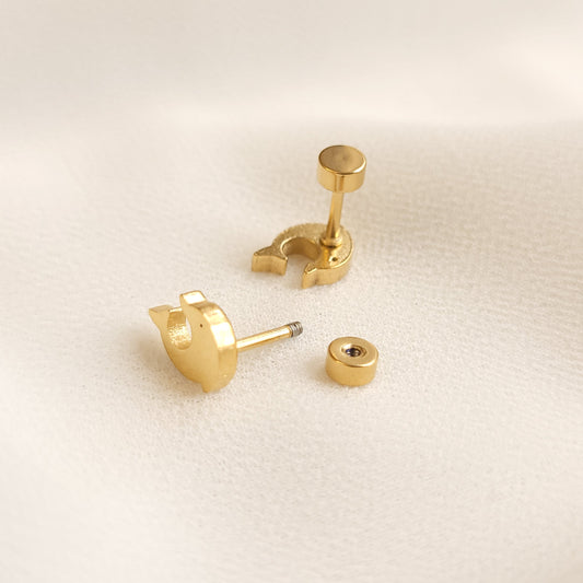 Gold-tone stud earrings demonstrating screw-on backings, with one backing attached and one removed to show the threaded post.