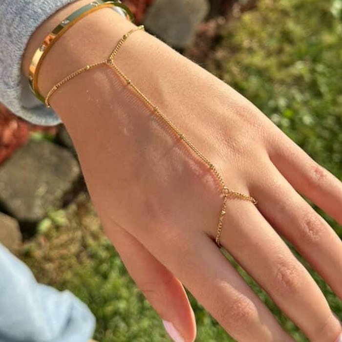 Gold Dainty Hand Chain worn on a hand alongside a polished gold bangle.