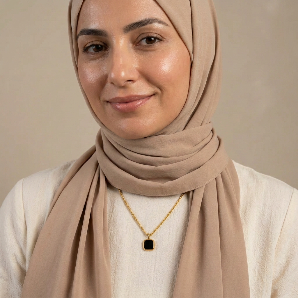 Model wearing the Black Square Pendant necklace with a beige headscarf and cream top.