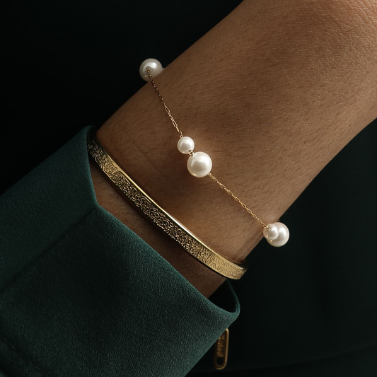 Model wearing the Doubled Up Pearl Bracelet stacked with an engraved gold bangle.