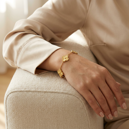 Model wearing the Gold Clover Bracelet, showing its textured clover charms and fit around the wrist.