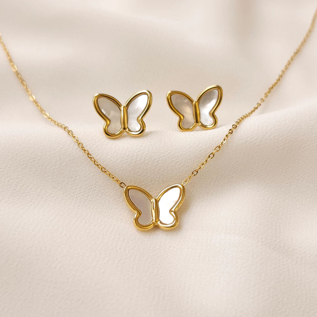 Mother of Pearl Set with a gold butterfly pendant necklace and matching stud earrings featuring pearly white wings.