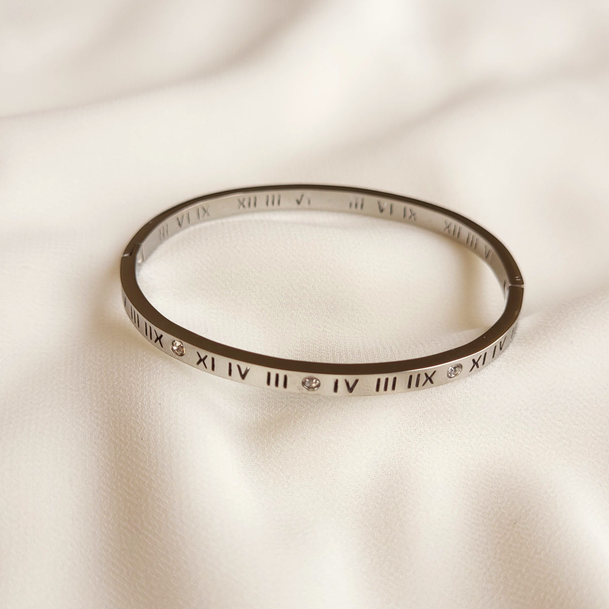 Roman Numeral Bangle in silver tone, showing black engraved numerals and round clear stone accents