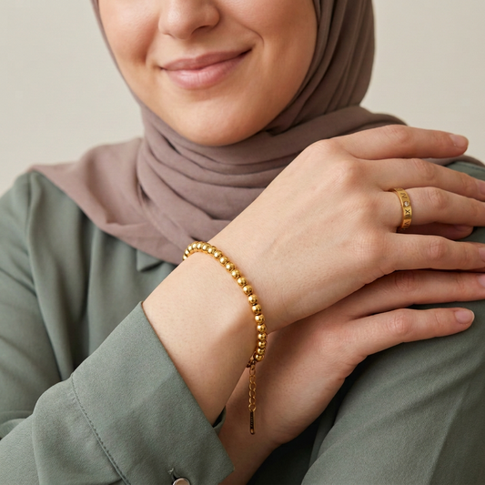Natural-looking model wearing the gold beaded bracelet and Roman numeral ring