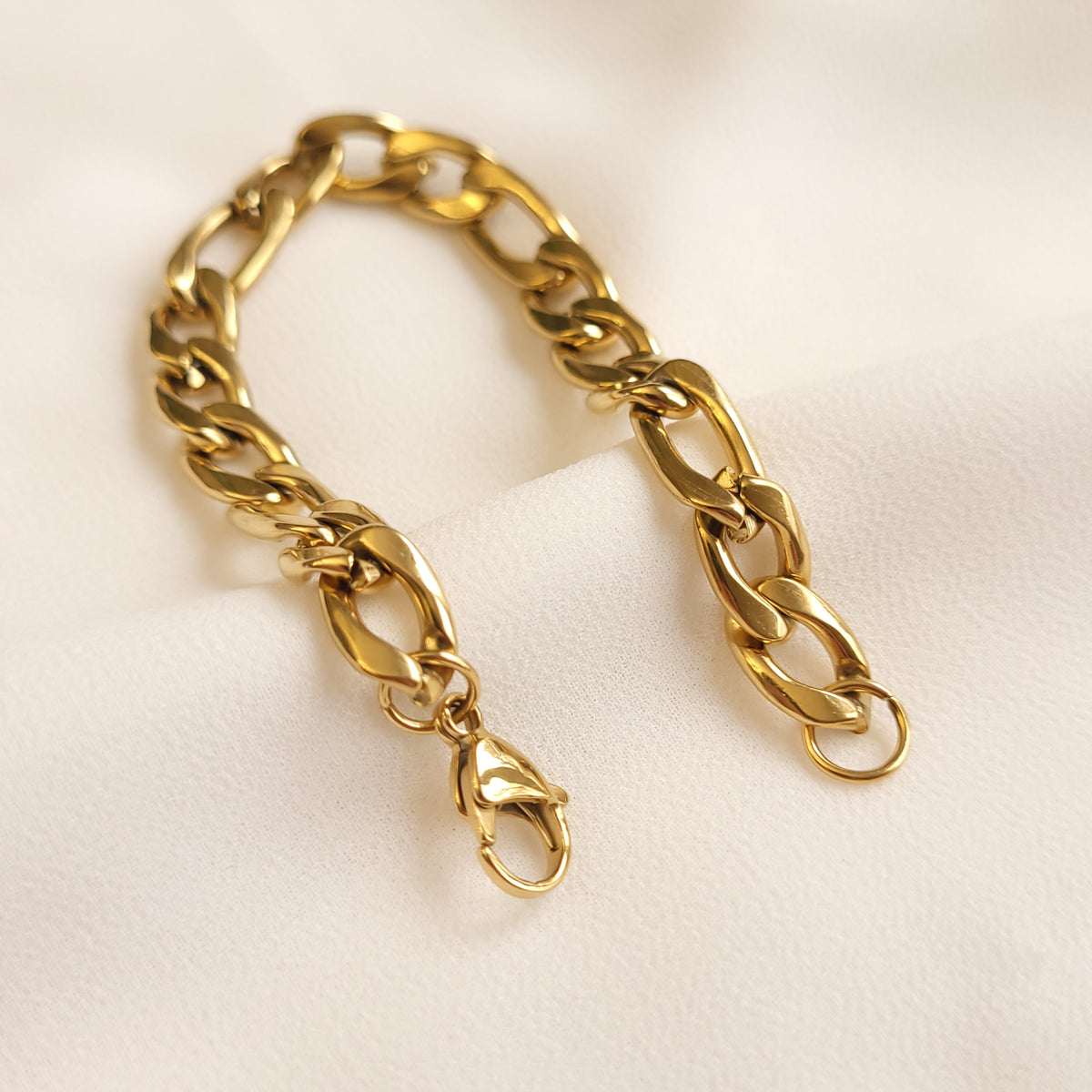 Chunky Figaro Bracelet laid open, showing the gold-tone lobster clasp and end ring.