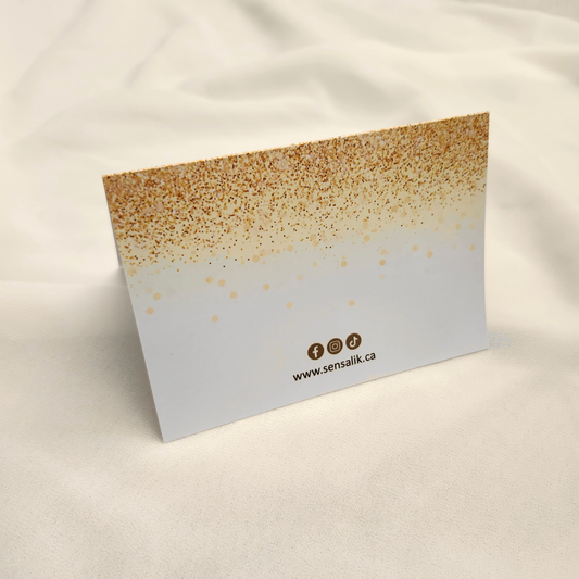 Back of the Sensalik Message Card with a gold speckled border, social media icons and sensalik.ca.
