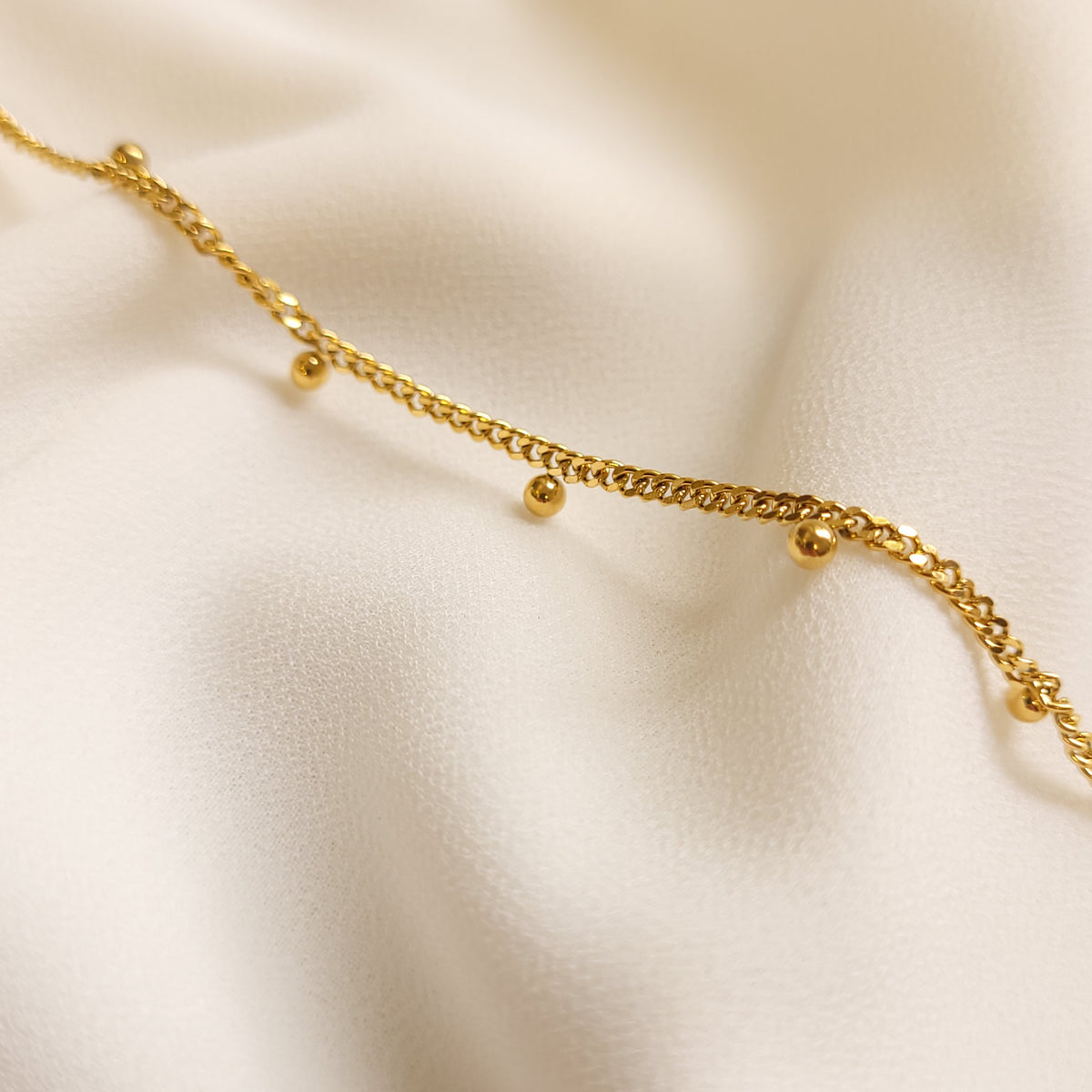 Children's Dangling Dots Bracelet close-up showing the gold-tone curb links and polished dangling ball charms.