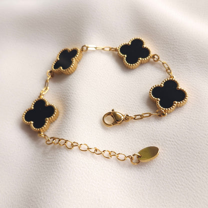 Children’s black clover bracelet laid open, showing the gold-tone clasp and extension chain.