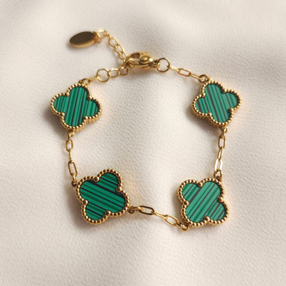 Children’s gold-tone bracelet with four green striped clovers and beaded borders.