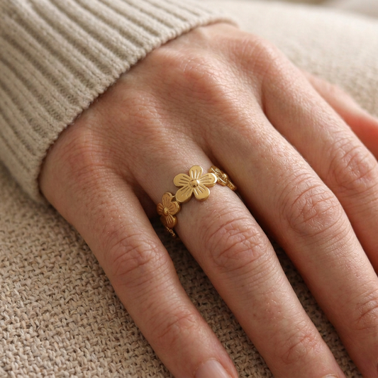 Close-up of a model wearing the gold Flower Ring, showing its engraved floral design