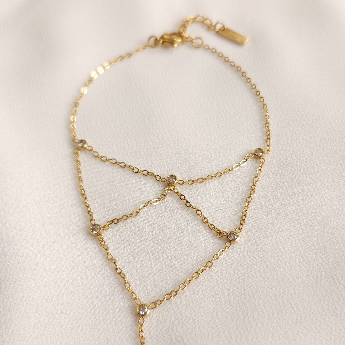 Close-up of the gold Mesh Hand Chain showing fine links and round clear stones at the chain junctions