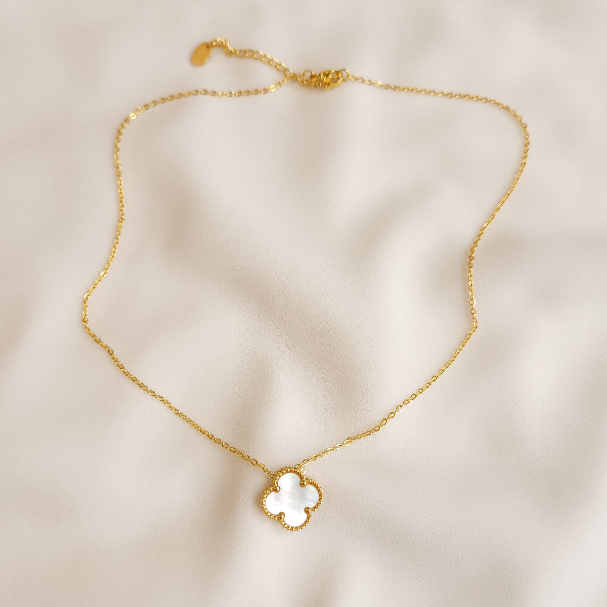 Clover Pendant Necklace in white laid out to show the full gold-tone chain, clasp, and extension chain.
