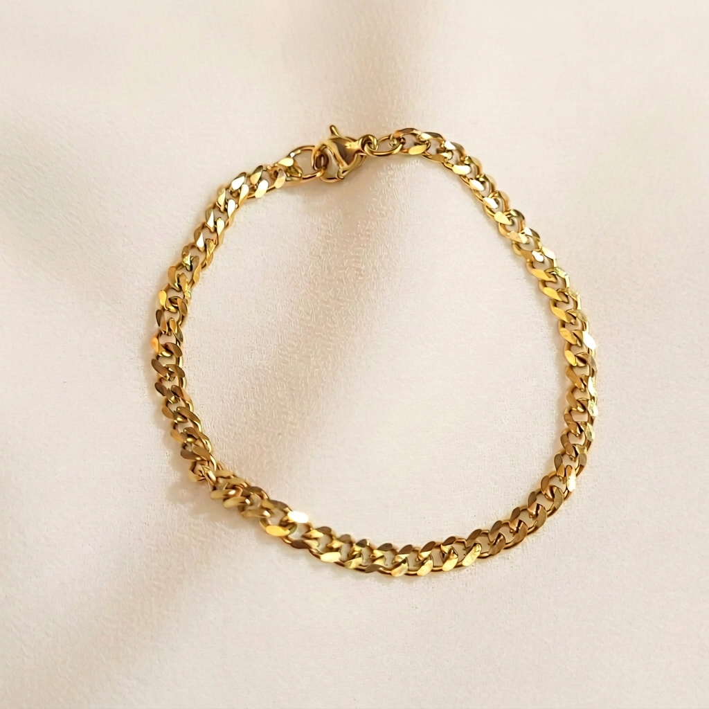 Dainty Cuban Chain Bracelet in gold tone arranged in a loop, showing polished curb links and a lobster clasp.