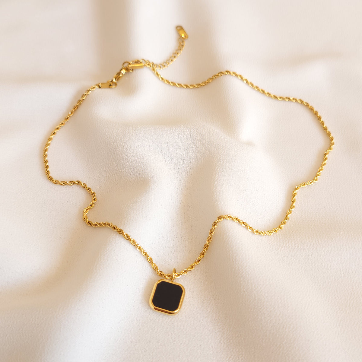 Full view of the Black Square Pendant necklace showing its gold-tone rope chain, clasp and extender.
