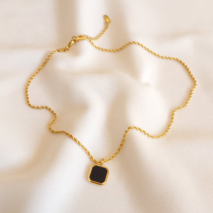 Full view of the Black Square Pendant necklace showing its gold-tone rope chain, clasp and extender.
