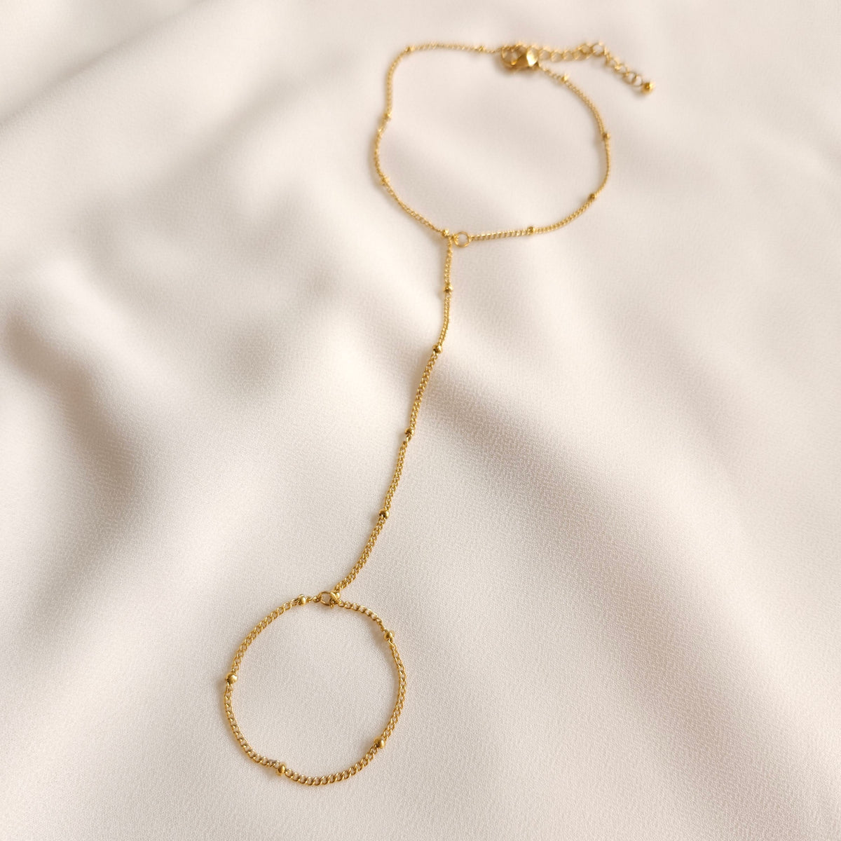Full view of the gold Dainty Hand Chain showing the finger loop, beaded connecting chain and wrist extension.
