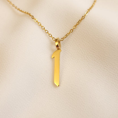 Gold-tone Arabic Initial Necklace with the letter Alif (ا) on cream fabric.
