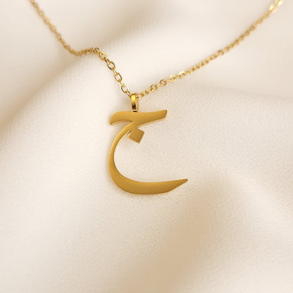 Gold-tone Arabic Initial Necklace with the letter Jeem (ج) on a fine link chain.
