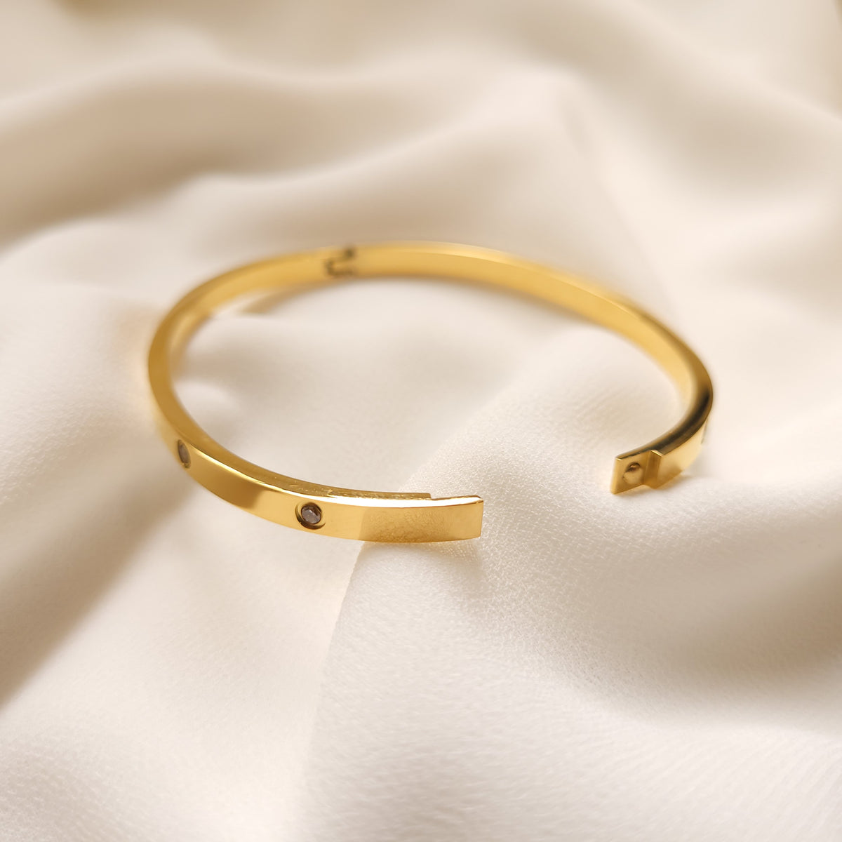 Gold-tone Crystal Stud Bangle with its clasp unfastened, showing the fastening ends.
