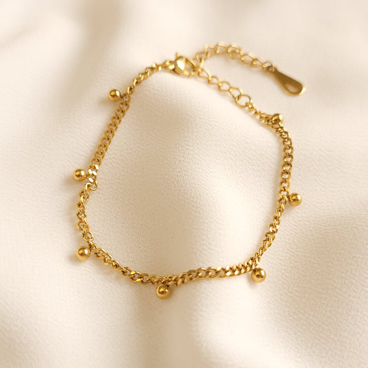 Gold-tone Dangling Dots Bracelet with a curb chain, small round dangling charms and an adjustable extender.
