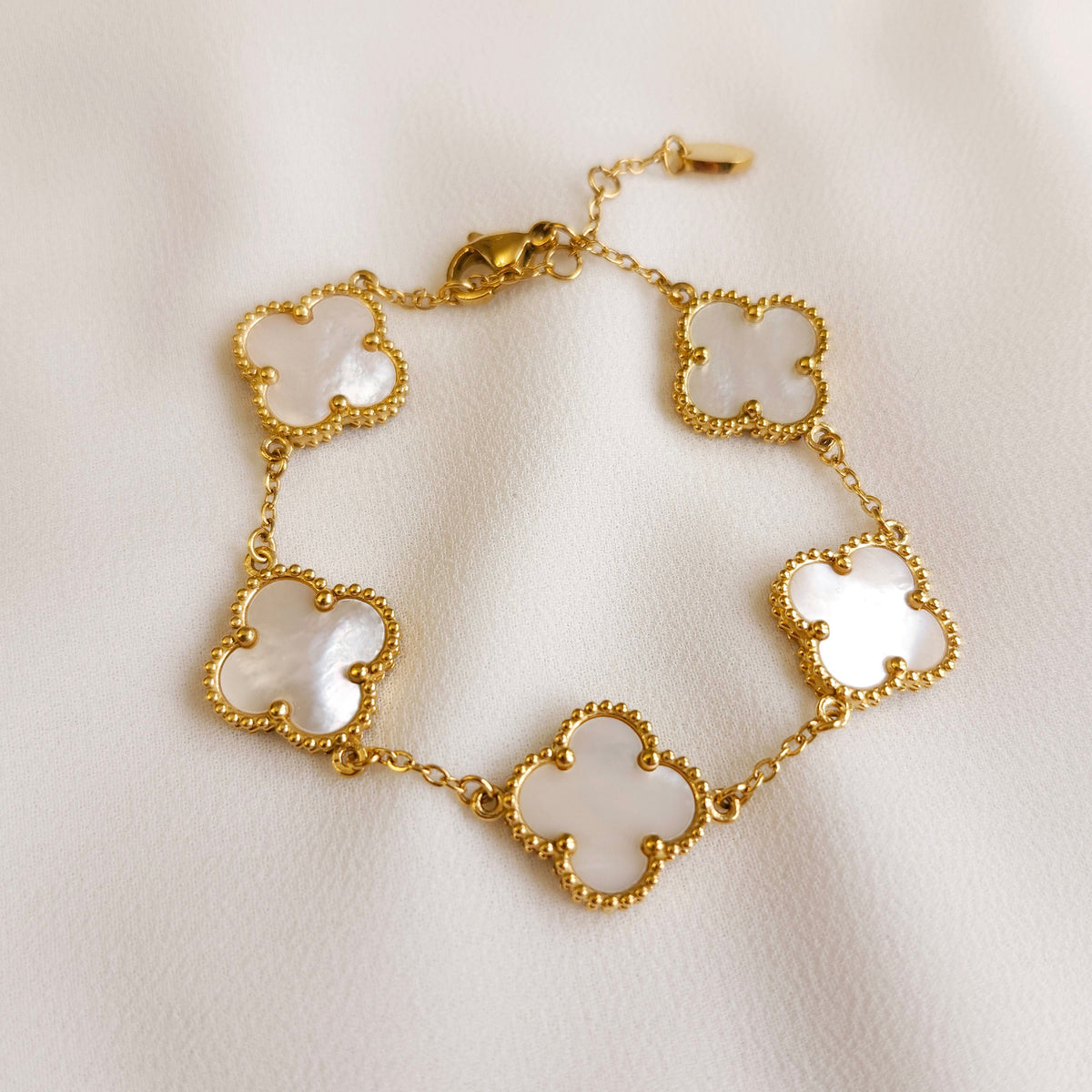 Gold Clover Bracelet with five pearly white clover charms, beaded borders and an adjustable chain.

