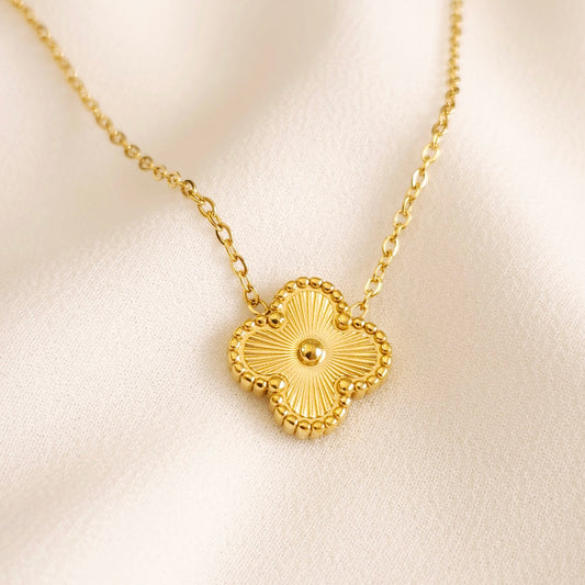 Gold Clover Pendant Necklace with engraved sunburst lines, a raised centre bead and a beaded border on a fine chain.
