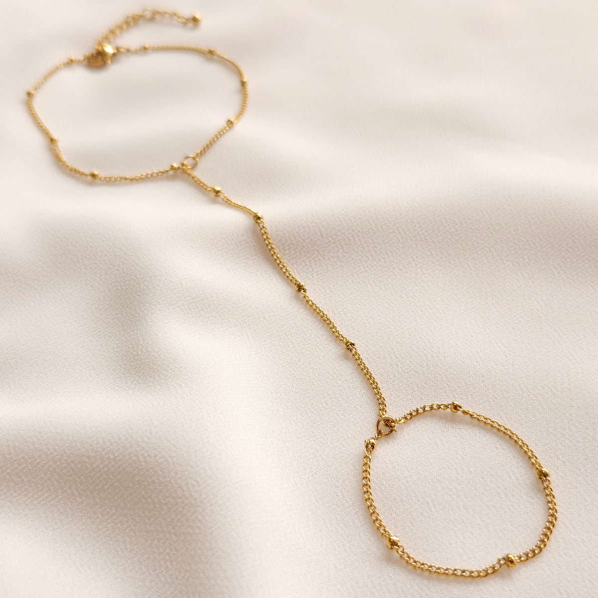 Gold Dainty Hand Chain with small spaced beads, a finger loop and an adjustable wrist chain.
