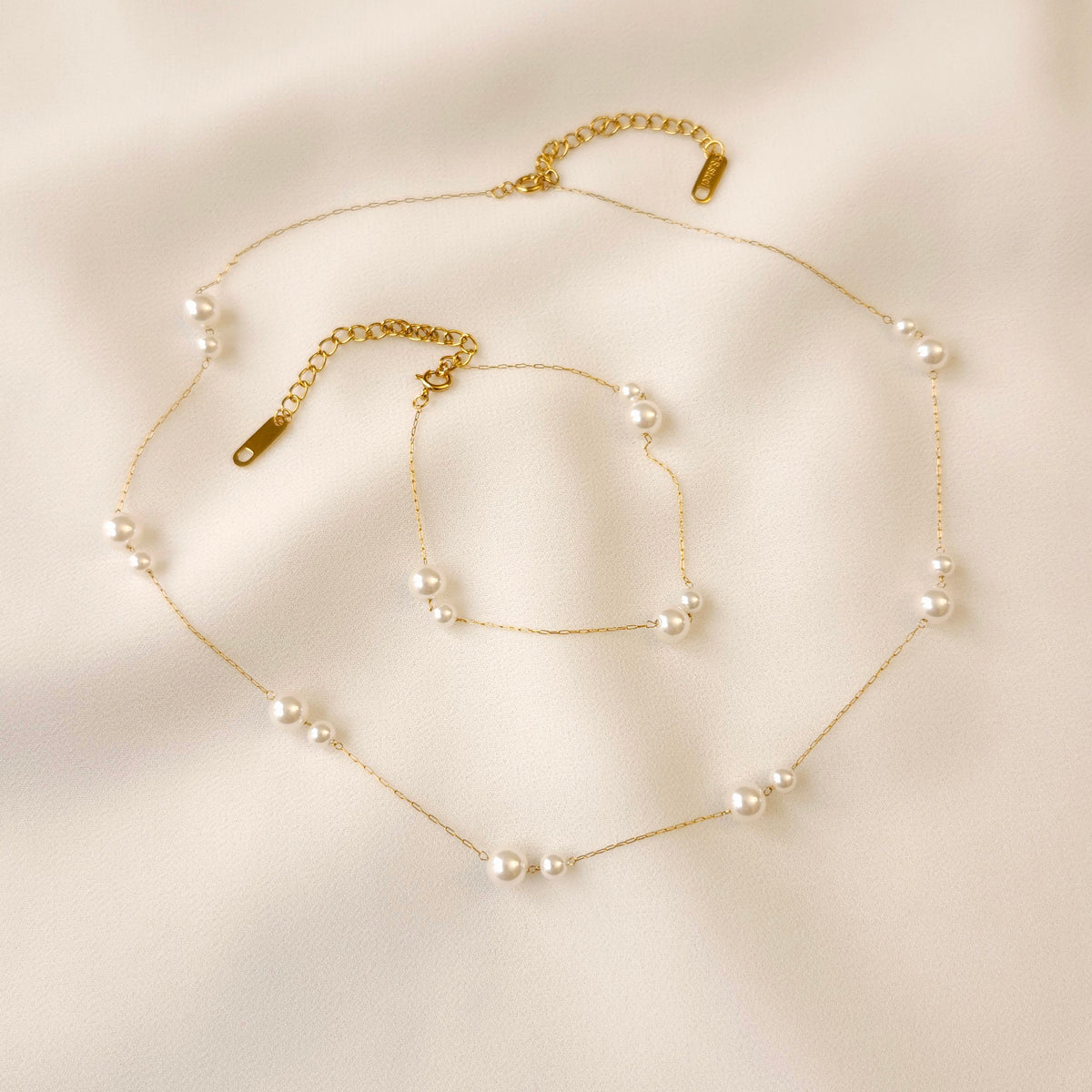 Gold Doubled Up Pearl Bracelet and matching necklace with paired white pearls and adjustable extension chains.
