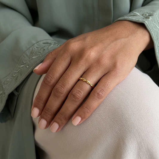 Gold Entwine Ring worn on a model’s finger, showing its delicate twisted design.