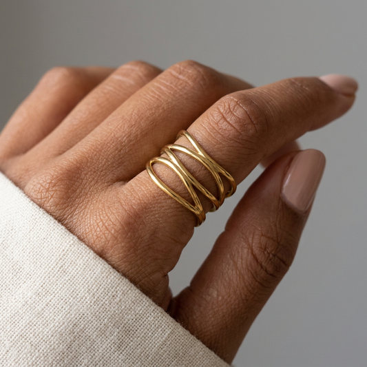 Gold Eternal Flow Ring worn on a model’s finger, showing its flowing openwork bands.