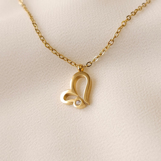 Gold Heart Sparkle Necklace with an asymmetric open-heart pendant and a round clear stone accent on a fine chain.
