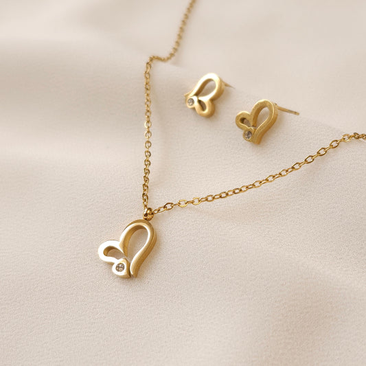 Gold Heart Sparkle Set with an asymmetric open-heart pendant necklace and matching stud earrings accented with clear stones.
