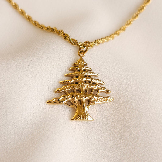 Gold Lebanon Cedar Necklace with a textured cedar tree pendant on a twisted rope chain.

