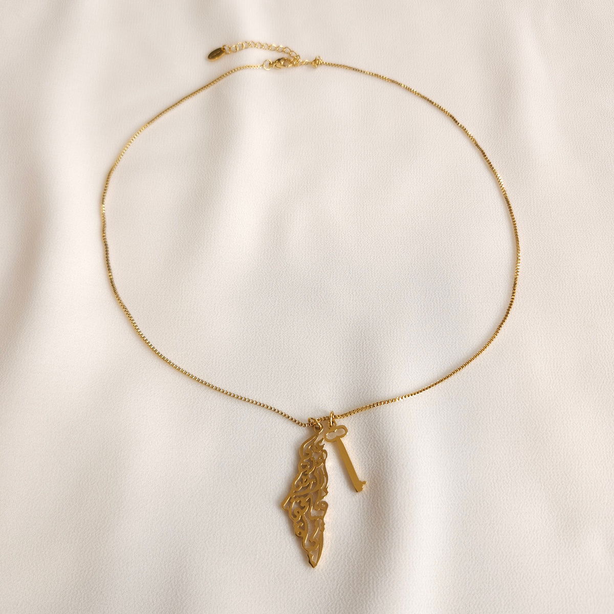 Gold Palestine Calligraphy & Key Necklace showing the box chain, map and key pendants, clasp and extension