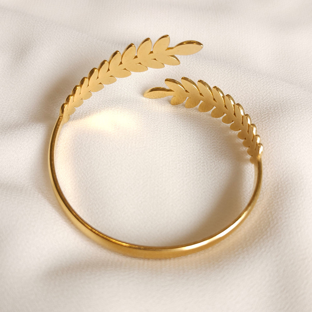 Inside view of the gold Leaf Cuff showing smooth leaf backs, a slim polished band and open ends.
