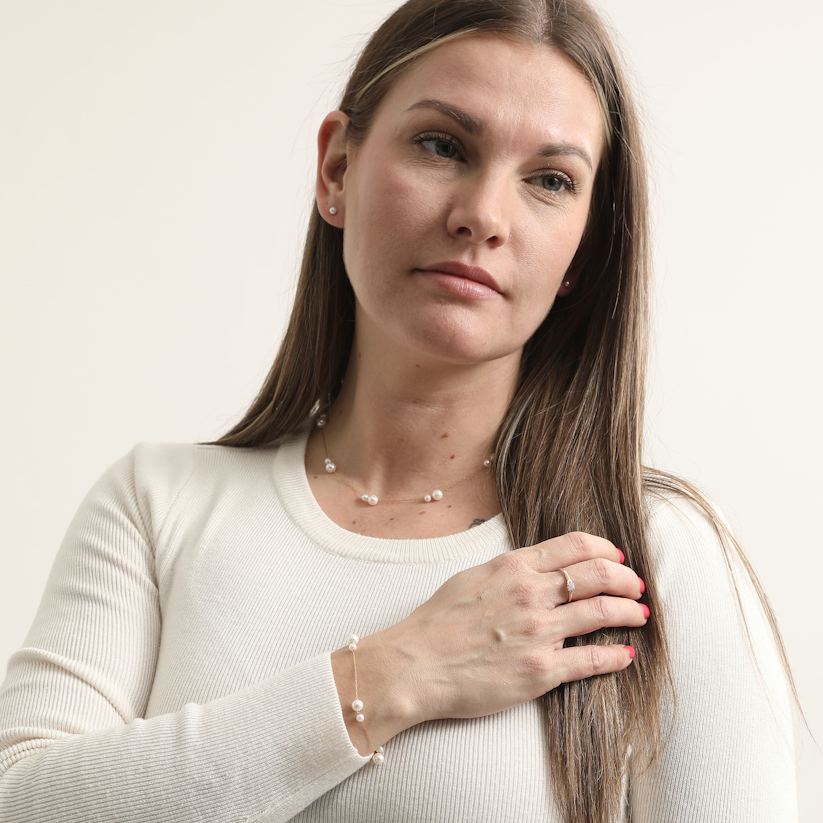 Model wearing the Doubled Up Pearl Bracelet with its matching pearl necklace and small stud earrings.
