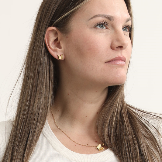 Model wearing the gold-tone Sparkling Butterfly Necklace with matching butterfly stud earrings and a white top.