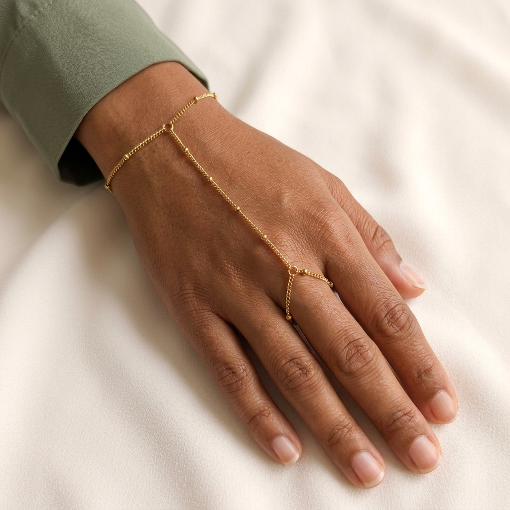 Model wearing the gold Dainty Hand Chain with a fine beaded chain connecting the wrist bracelet to the finger loop.
