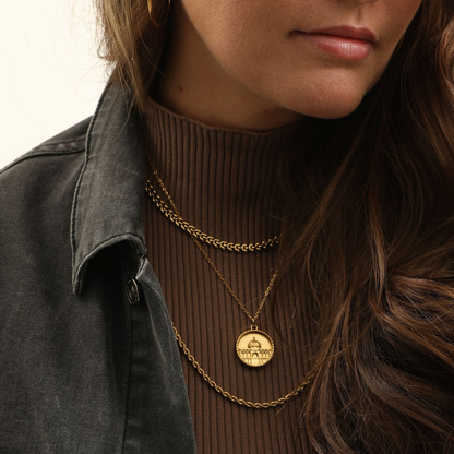 Model wearing the gold Dome of the Rock Coin Necklace layered with two other gold chains.