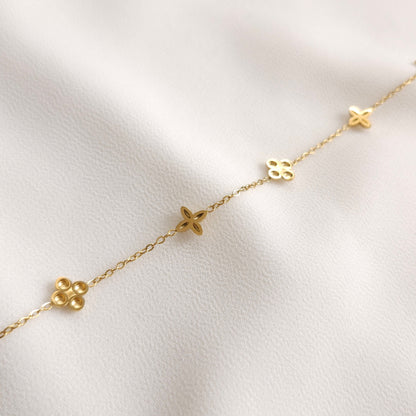 Reverse side of the gold Dainty Flower Bracelet showing the backs of its alternating floral charms.
