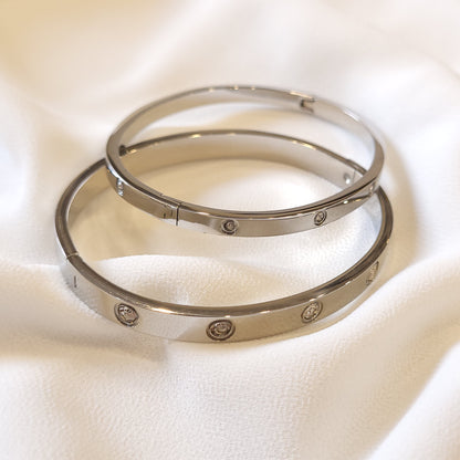 Two silver-tone Crystal Stud Bangles with narrow and wide bands and round clear stones.
