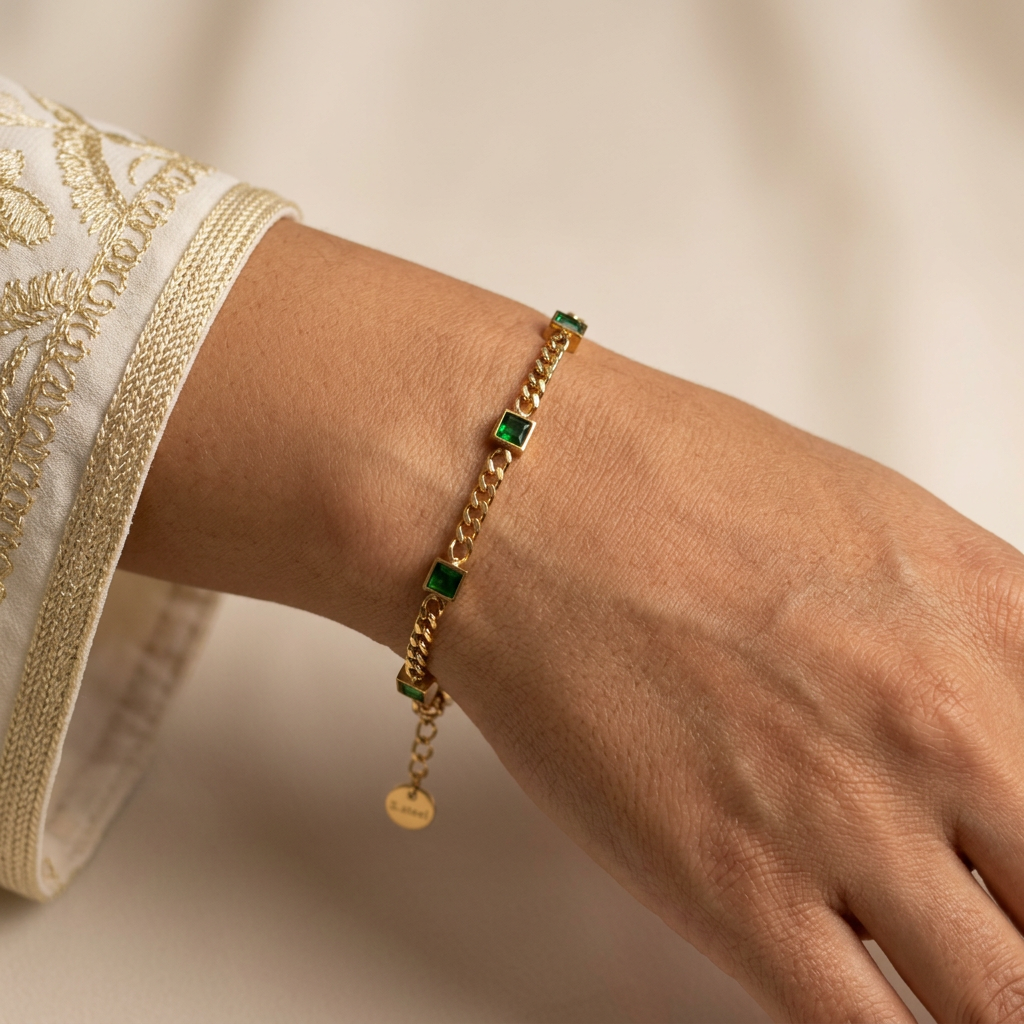 Close-up of the green-and-gold bracelet on a model’s wrist